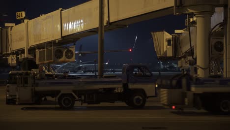 airport jet bridge and loading trucks at night