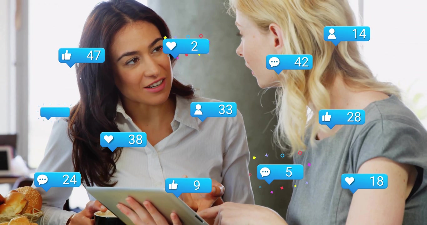 Dos mujeres abriendo una publicación de redes sociales en una tablet, rastreando datos a través de iconos animados que suben por encima de ellas