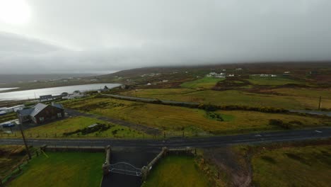 Drone-flying-fast-over-a-house-towards-the-calm-Atlantic-Ocean-on-Achill-Island