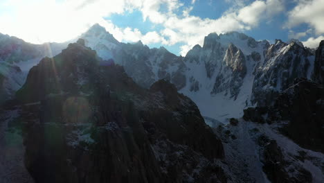 Epic-aerial-drone-shot-going-through-an-opening-to-see-the-Ak-Sai-glacier-in-Kyrgyzstan