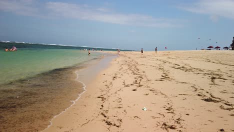 walking around on nusa dua beach on sunny windy summer day with ocean blue in background and amazing yellow sandy beach.