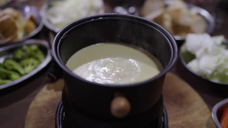 argentine bagna cauda bubbling at table with vegetables and bread, traditional food sharing moment