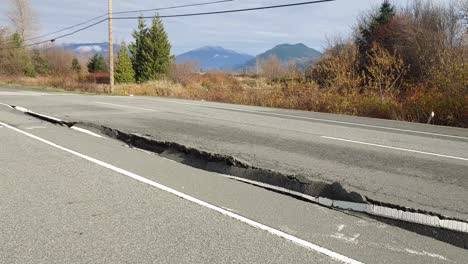 view of a destroyed traffic road, a cracked road with potholes, earth activity destroyed the road