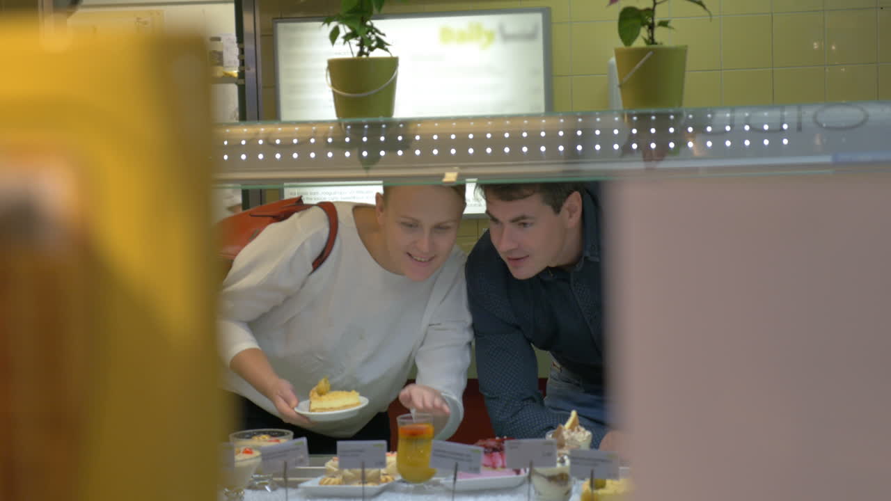 Uomo e donna che scelgono il dessert in caffetteria