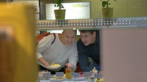 Man-and-woman-choosing-dessert-in-cafeteria