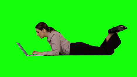 mujer de negocios usando portátil contra pantalla verde