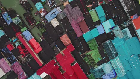 Top-Down-View-of-Rooftops-at-Koh-Panyee-Island-with-an-Aerial-Drone-Rising-Higher-Above-the-Village,-Phang-Nga-Bay,-Thailand