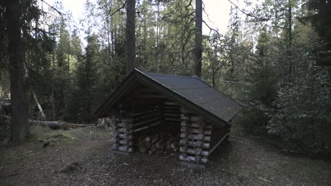 Slow-motion-shot,-towards-a-woodshed,-in-a-finnish-forest,-on-a-cold-and-cloudy-autumn-day,-near-Joensuu,-Pohjois-Karjala,-Finland