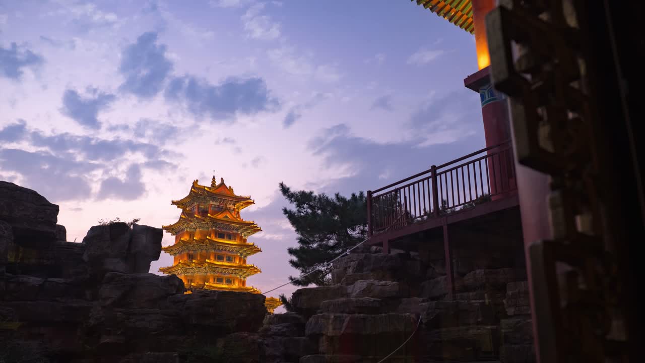 4K time-lapse of golden pagoda against fiery sunset sky and rocky silhouette in penglai, shandong, China