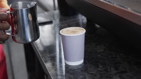 Midsection-of-african-american-male-baker-making-coffee-in-bakery,-slow-motion