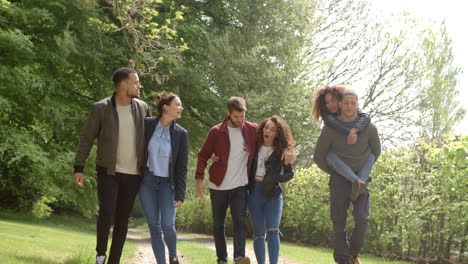 Junge-Paare,-Die-Auf-Einem-Feldweg-Spazieren-Gehen-Und-Huckepack-Fahren