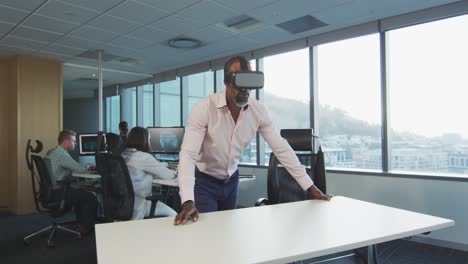 African-American-businessman-wearing-VR-headset-in-modern-office