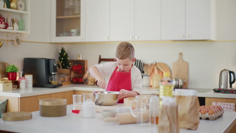 boy prepares bread dough in the kitchen