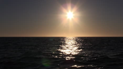 puesta de sol con rayos que brillan en el mar