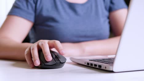 Woman-working-on-laptop-and-using-wireless-mouse