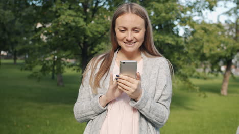 mujer usando el teléfono en un parque