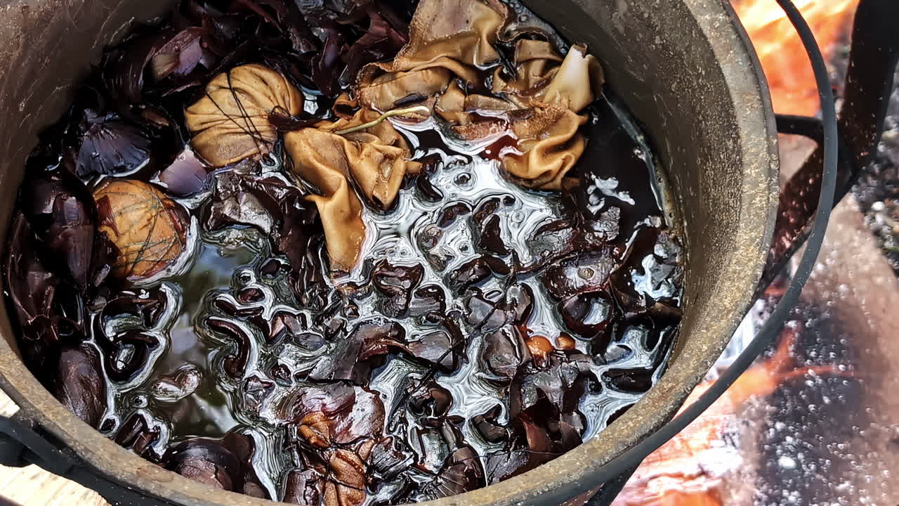 Stoofpot met groenten en vlees, soep sudderend op houtvuur in buitenkeuken met grote vlammen