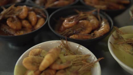 small cups filled with shrimp with different sauces