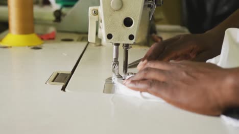 hombre africano cosiendo tejido