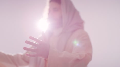 retrato retroiluminado de un hombre vestido con túnicas con cabello largo y barba que representa la figura de jesucristo orando