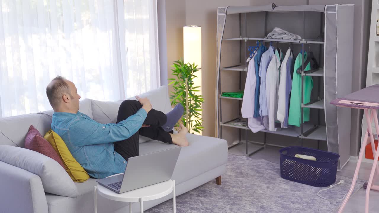 집에 오는 남자는 그의 양말을 더러운 바구니에 던집니다.