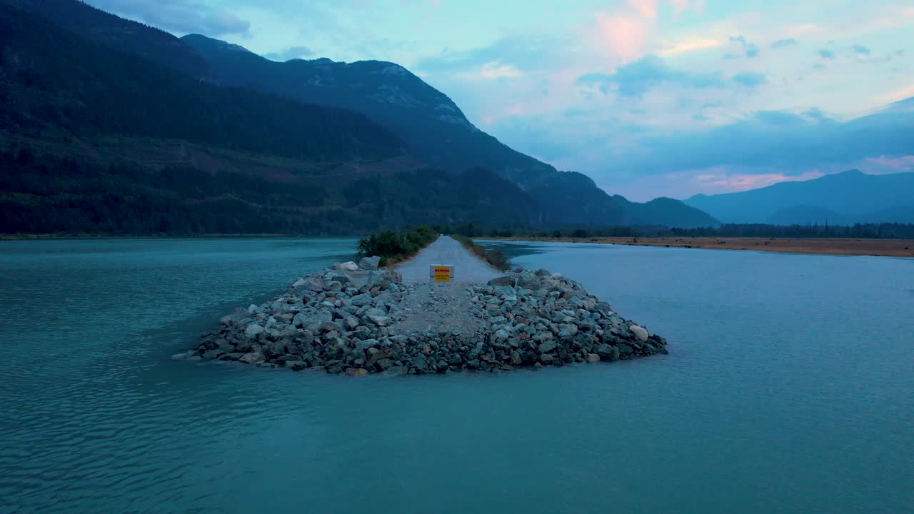 vuelo de drones sobre la suciedad de grava estrecha fuera de la carretera en el área de conservación restringida del río squamish