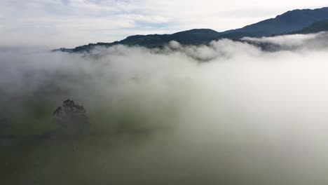 thick fog on a large grassland area with hills in the background