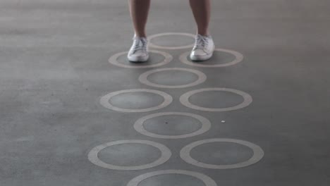 person playing hopscotch, advancing through squares.