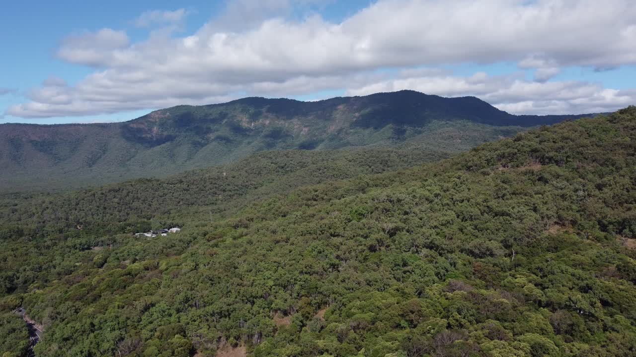 Drone ascending over a mountain with green tropical vegetation in North Queensland, Australia