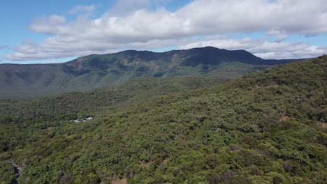 drone ascending over a mountain with green tropical vegetation in north queensland, australia