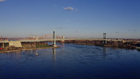 east river amidst buildings in city, drone flying backward from skyline