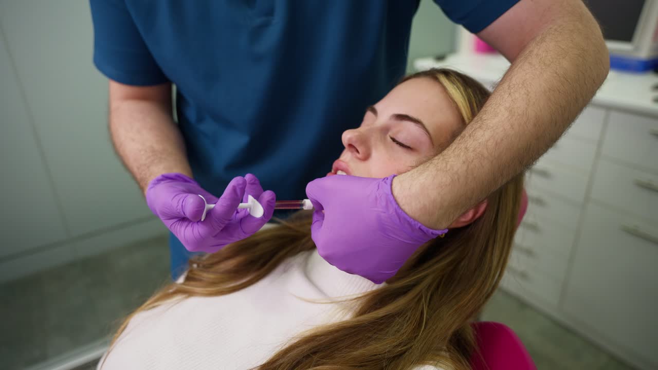 Giovane donna che si sottopone a un trattamento cosmetico di aumento delle labbra