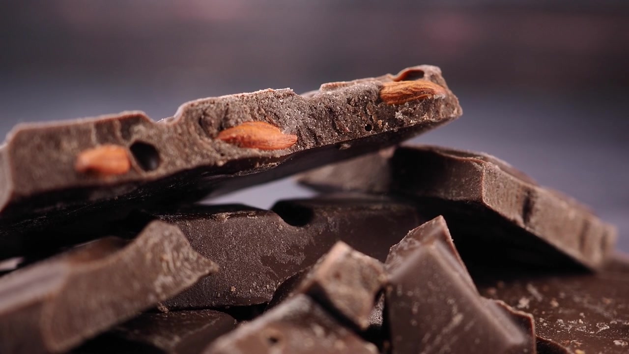 Close-up Potongan Cokelat Hitam yang Patah dengan Kacang Almond