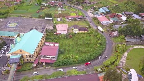 Top-down-aerial-view-of-a-calm-and-quiet-village-with-narrow-road-and-a-helipad-in-Asian-Country,-Berastagi,-North-Sumatera,-Indonesia