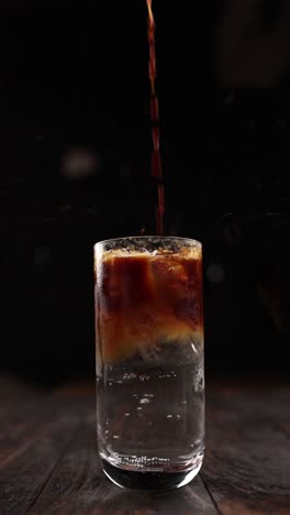 pouring iced coffee into a glass with ice