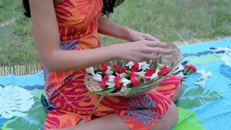 Junge-Frau-Arrangiert-Blumen-Auf-Einer-Matte-Im-Garten-4k