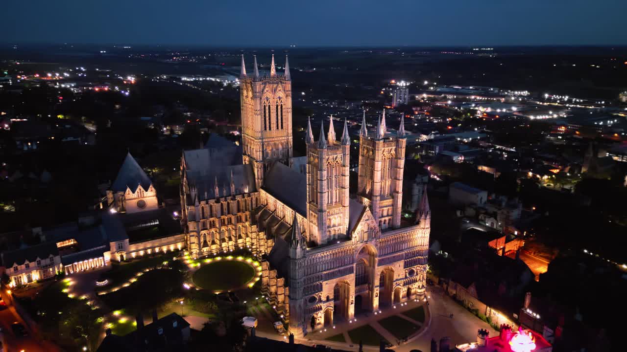 영국의 랜드마크인 링컨 대성당 (lincoln cathedral) 의 드론 영상, 어두워지면서, 조명된, 웅장한 고 건축물을 특징으로합니다.