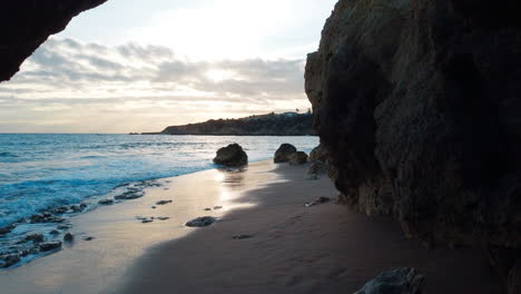 Moving-along-the-rocky-beach-structure-and-revealing-to-vast-Atlantic-ocean-surface-at-the-beach,-location-Portugal