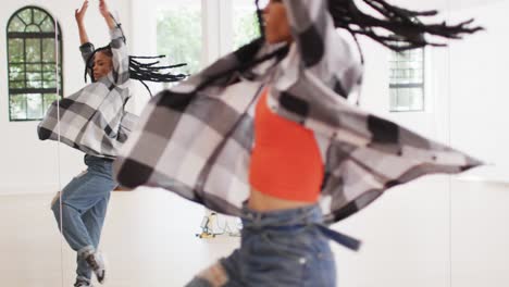 portrait of happy diverse male and female dancers dancing in dance studio, slow motion