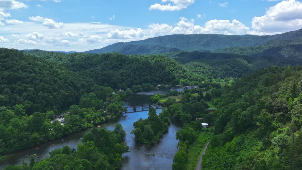 Static aerial timelapse of the Hiawassee River in Tennessee with people in tubes and clouds moving overhead.