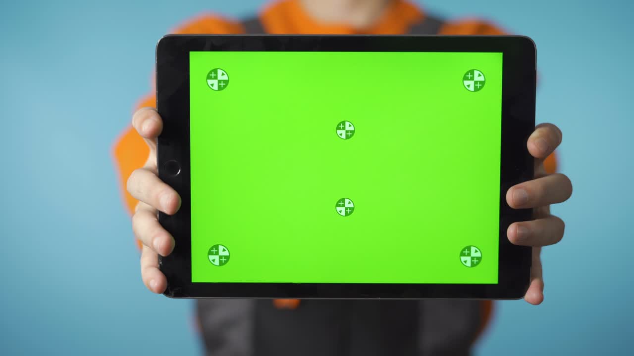 fotografía cercana de una tableta con pantalla verde sostenida por un trabajador de la construcción