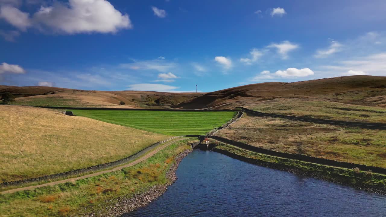 Aerial drone video footage taken at Ogden Saddleworth moor in Oldham, England of a series of Lakes, Reservoirs, set against a backdrop of moorland, woodlands and blue sky's