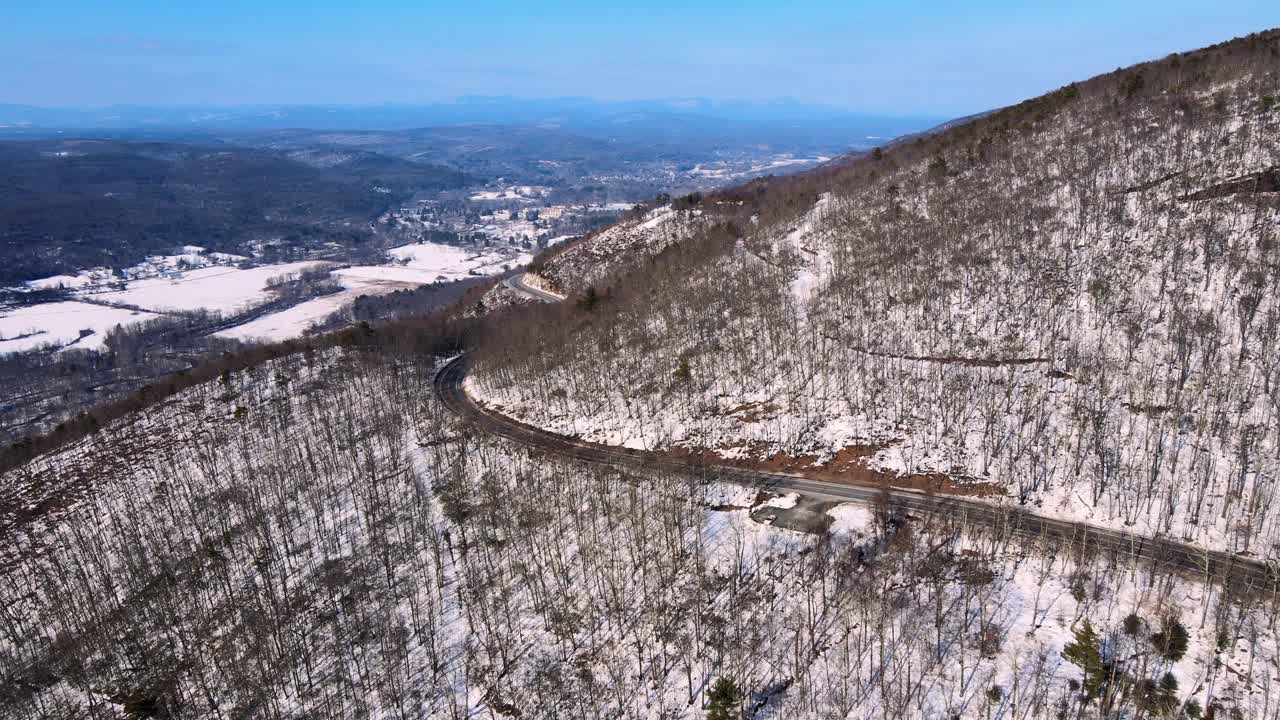 видеосъемка с беспилотного летательного аппарата заснеженной, с голубым небом горной долины, проходящей через горы в аппалачах на хребте шаванганк, в штате нью-йорк