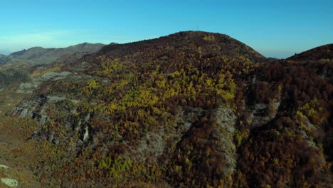 laderas de montaña cubiertas de follaje marrón amarillo de árboles forestales en la mañana de otoño