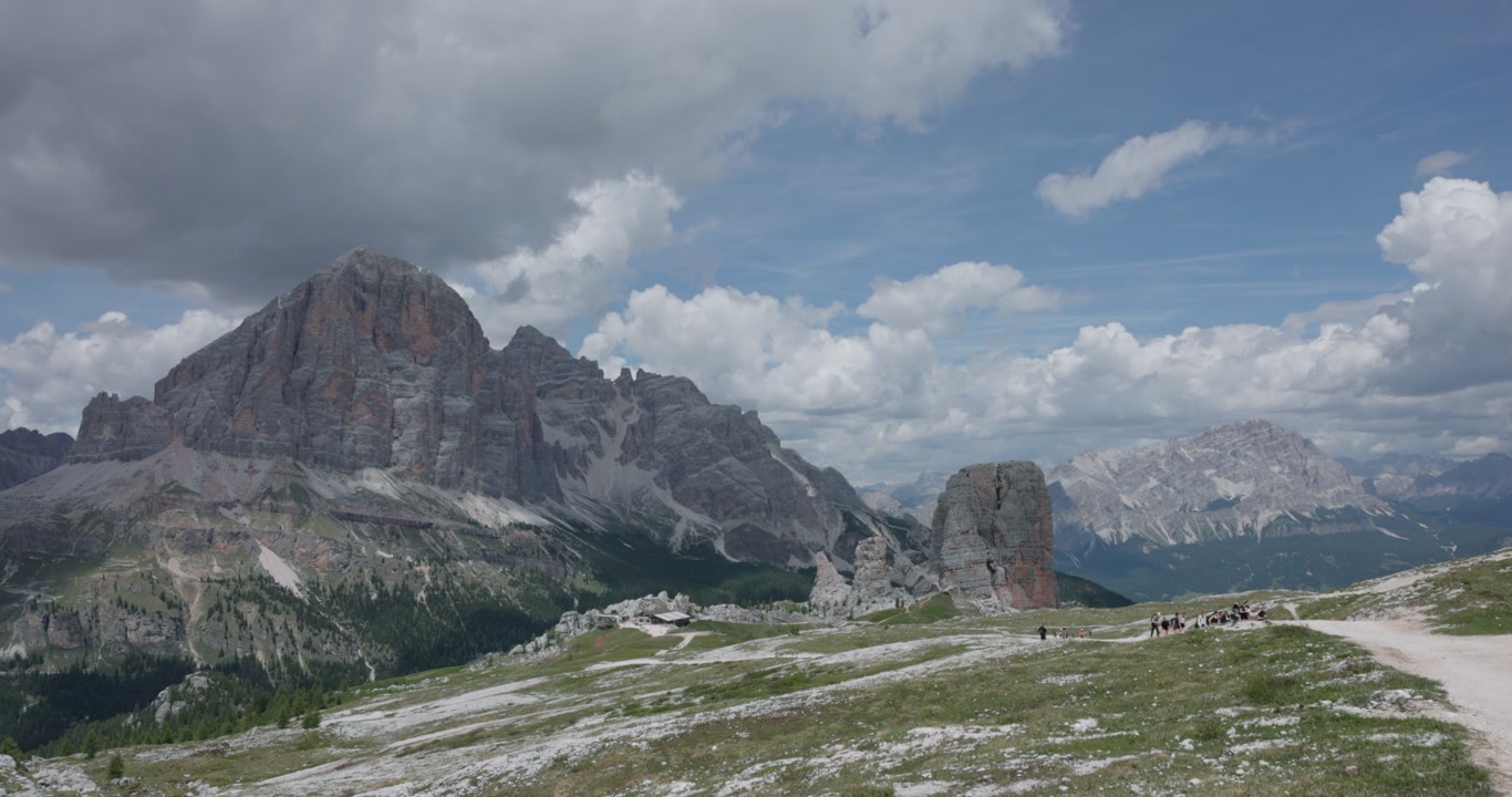 Imponenti montagne aspre con escursionisti alle Cinque Torri vicino a Cortina d'Ampezzo nelle Dolomiti, Italia. Inquadratura ampia