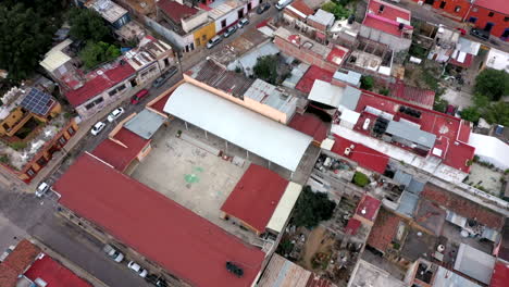 Aerial-view-of-the-city-of-the-historical-center-of-Oaxaca-in-Mexico,-filmed-by-a-drone-with-very-nice-tilt-up-displacement,-showing-Oaxaca's-event-center-on-a-hill