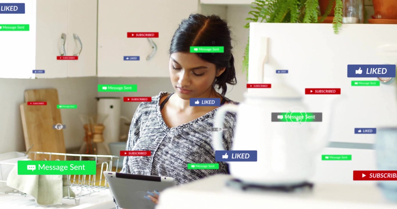 woman interacting with tablet in home kitchen, displaying floating social media pop-up labels