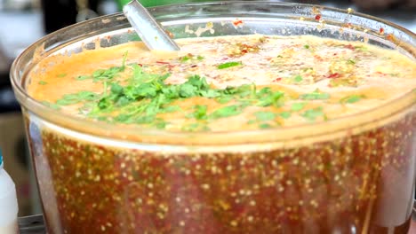 the bowl contains a thai-style chili soup, its fiery broth adorned with tantalizing toppings, emanating intense spiciness, this soup promises a flavorful and aromatic sensation