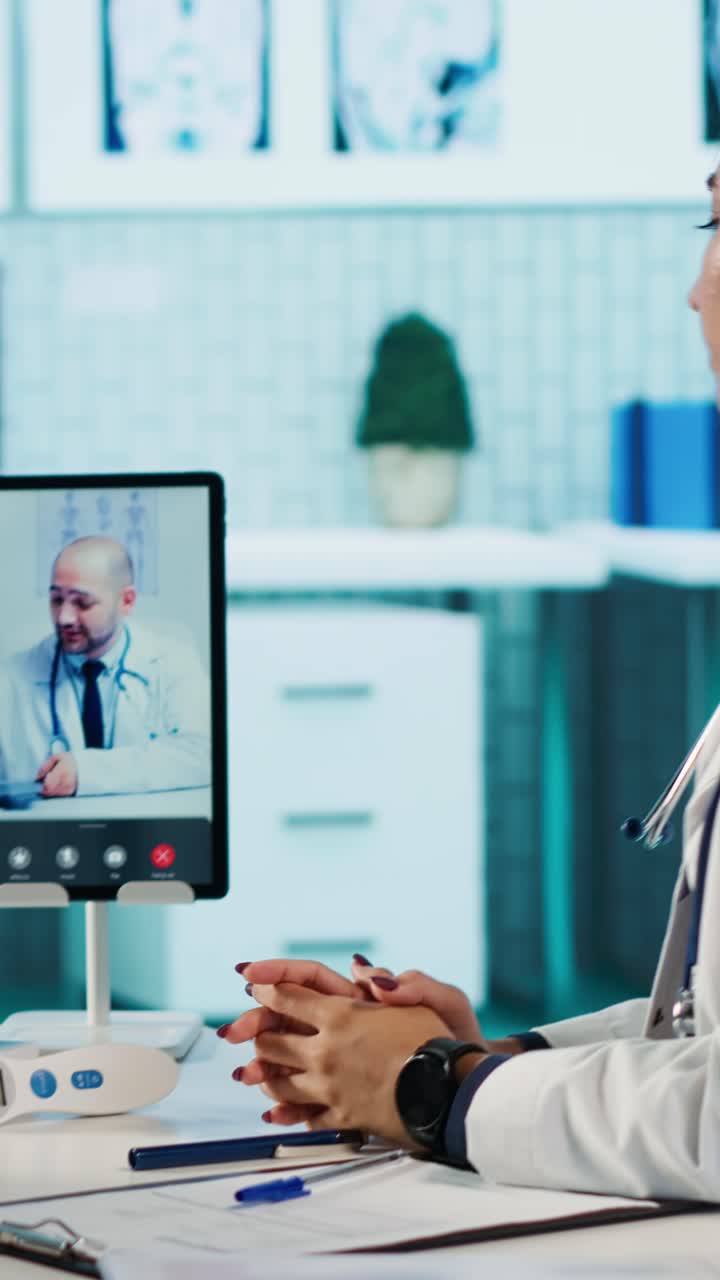 Dottoressa impegnata in una videochiamata di telemedicina con un collega.
