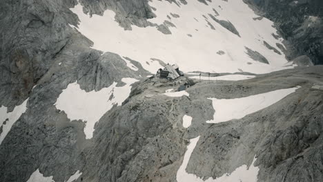 Foto-De-Las-Montañas-Eslovenas-Desde-Un-Helicóptero-De-Una-Cabaña-De-Montaña-Eslovena-En-Los-Alpes-De-Julijan,-Rodeada-De-Nieve-Y-Rocas